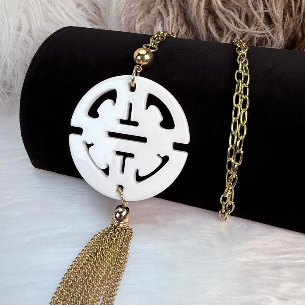 Long, goldtone, costume necklace, with large white pendant, and metal fringe